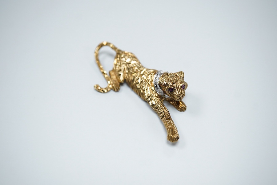 Two 9ct gold brooches, one designed as a collared leopard, its eyes set with rubies, length 5.2cm; the other designed as a hummingbird in flight, its eye set with an emerald, length 4.9cm, each in textured 9ct gold, Brit